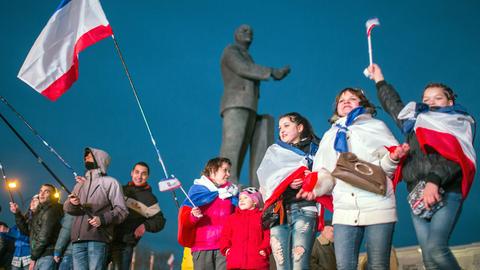 Menschen mit Russland-Fahnen jubeln auf dem Lenin-Platz in Simferopol auf der Krim.
