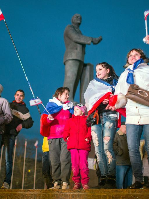 Menschen mit Russland-Fahnen jubeln auf dem Lenin-Platz in Simferopol auf der Krim.