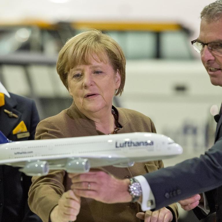 Bundeskanzlerin Angela Merkel (CDU) besucht am 18.11.2015 die Lufthansa in Frankfurt am Main (Hessen). Dabei nimmt Sie zusammen mit Lufthansa-Chef Carsten Spohr das Modell eines Airbus A380-800 in die Hand. Foto: Boris Roessler/dpa | Verwendung weltweit