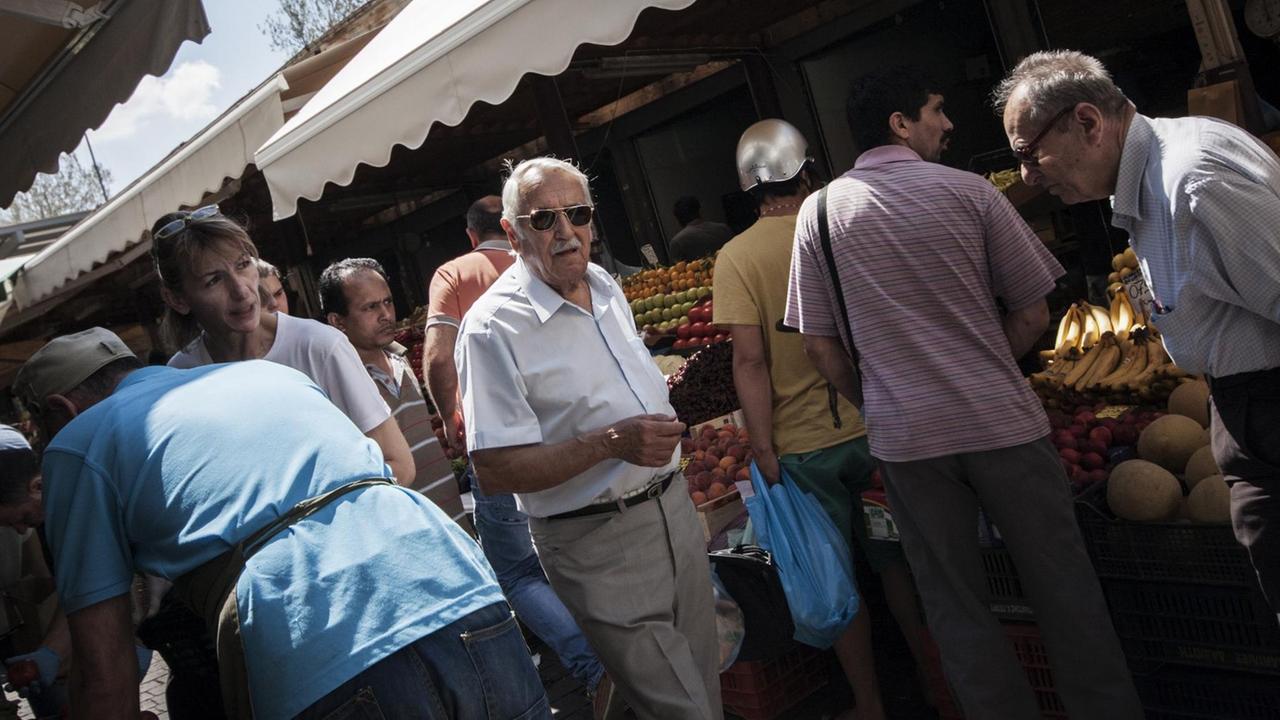 Menschen erledigen ihre Einkäufe auf einem Markt in Athen.