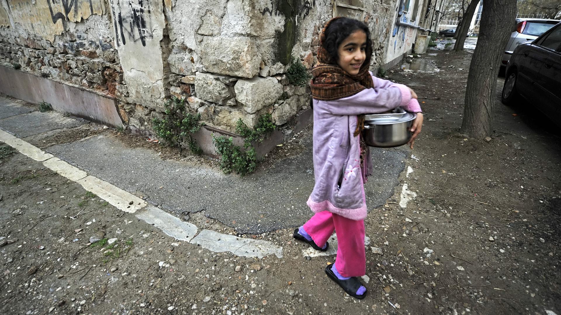 Ein Mädchen in Athen trägt einen Topf.