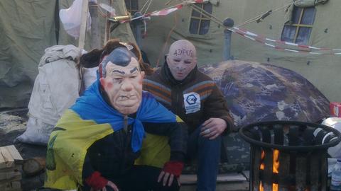 Zwei Demonstranten tragen eine Maske.