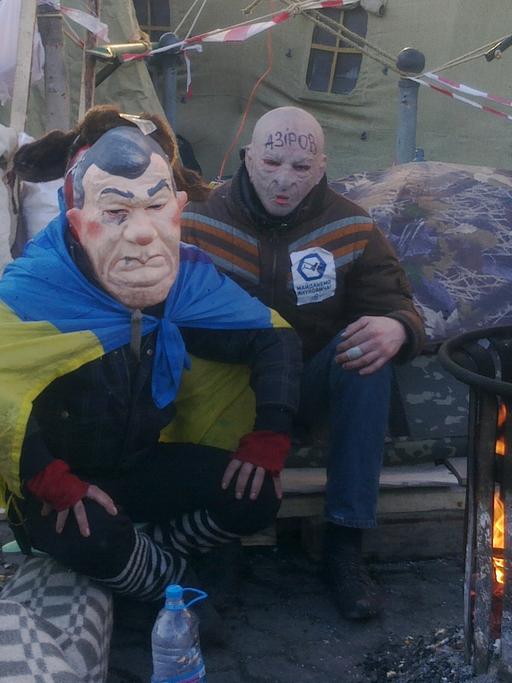 Zwei Demonstranten tragen eine Maske.