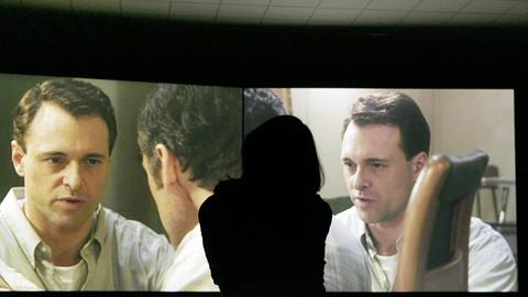 Eine Frau betrachtet 2007 im Württembergischen Kunstverein in Stuttgart die Zweikanal-Videoinstallation "Win, Place or Show" von Stan Douglas.