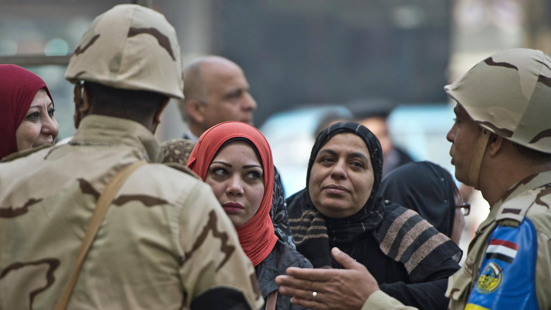 Soldaten und Frauen gestikulieren vor einem Wahllokal in Ägyptens Hauptstadt Kairo