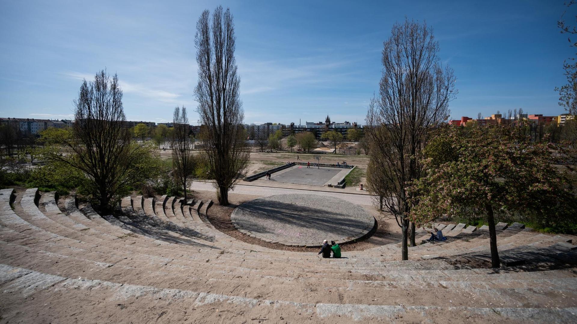 Zwei Menschen sitzen im sonst leeren Amphitheater des Mauerpark in Berlin Prenzlauer-Berg.