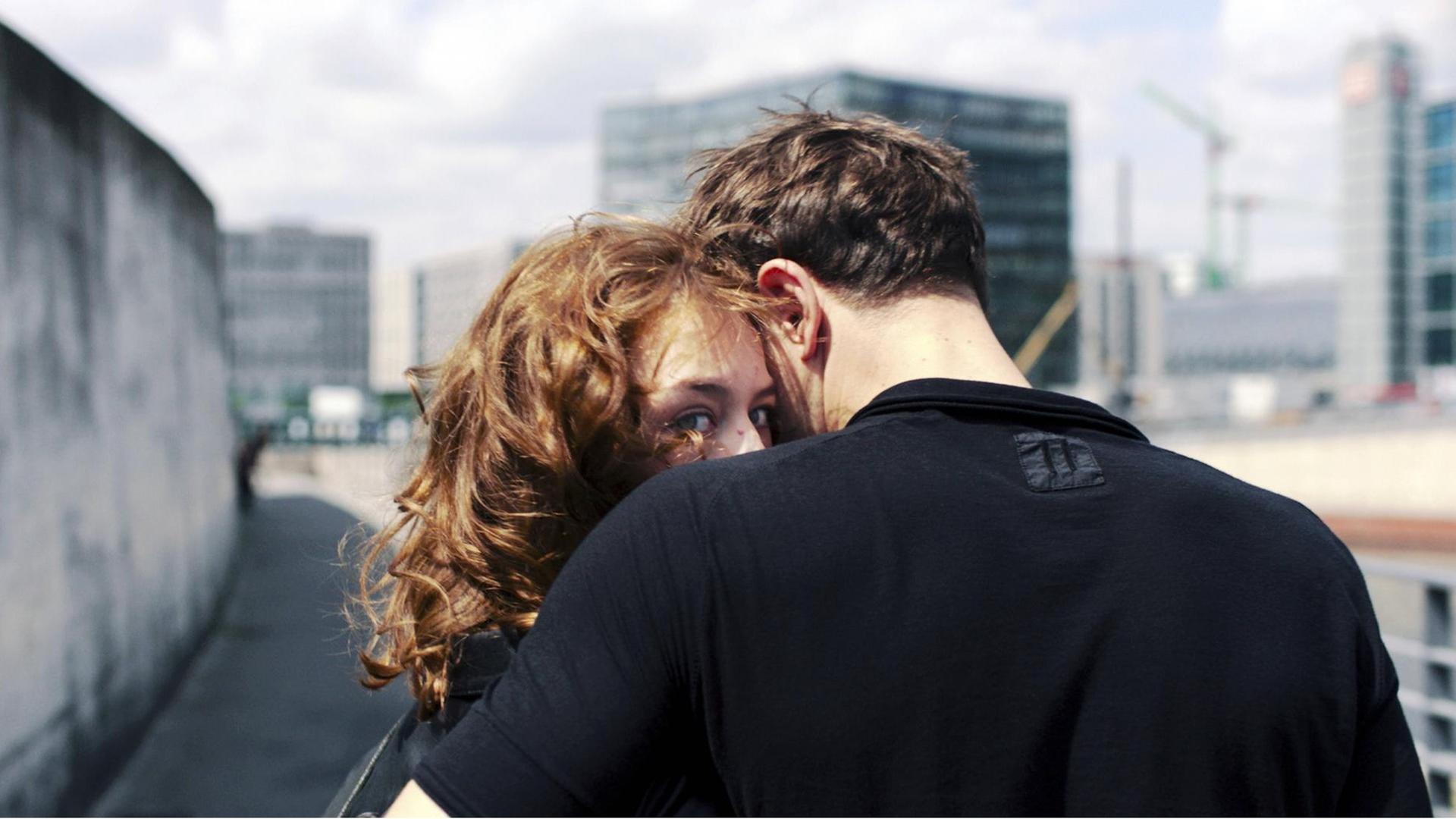 Filmstill aus Christian Petzolds Film "Undine": Ein Mann umarmt eine Frau an einer Mauer. Sie blickt in die Kamera, er in die andere Richtung.