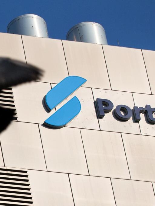 Eine Taube fliegt am 17.03.2015 in Düsseldorf (Nordrhein-Westfalen) am Logo der Portigon Bank vorbei.