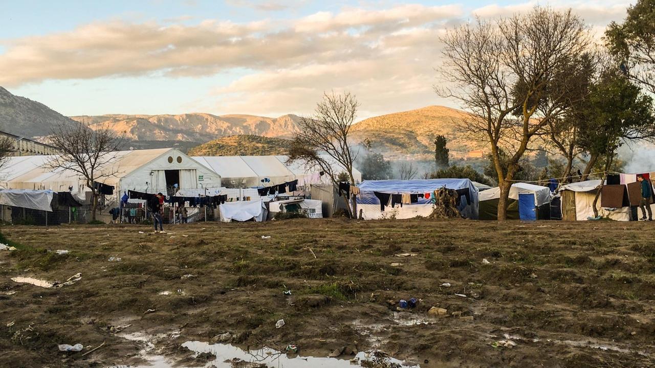 Blick auf das Hauptcamp für Flüchtlinge auf der Insel Chios: auf einem matschigen Acker stehen Zelte aus Plastikplanen.