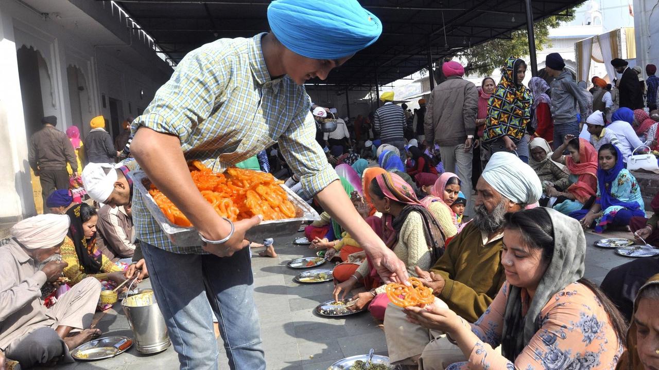 Menschen beim gemeinsamen Guru ka Langar zum 350. Geburtstag des 10. Sikh Guru Gobind Singh Ji in Panchkula, Indien am 5. Januar 2017
