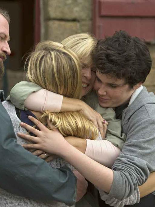 Filmszene aus "Verstehen Sie die Béliers?" zeigt eine vierköpfige Familie bei der gruppenumarmung.