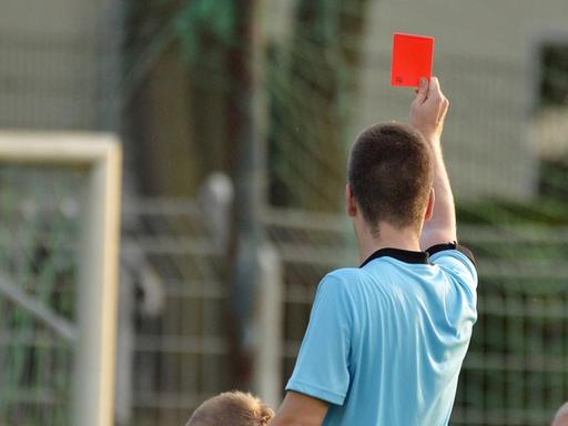 Ein Schiedsrichter zeigt eine rote Karte.