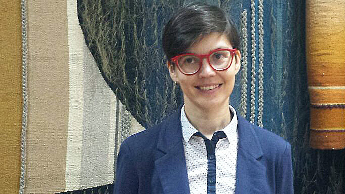 Anastasia Danilova, LGBT-Aktivistin in Chişinău. Eine junge Frau mit roter Brille und kurzen Haaren steht in einem Raum.