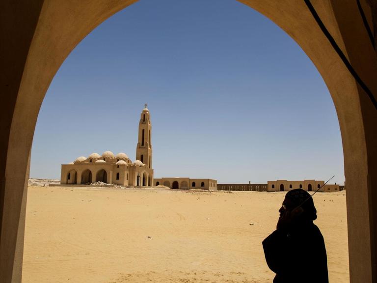 Ein koptischer Priester hält sich im Sankt Samuel Kloster in der Nähe von Minja (Ägypten) ein Radio ans Ohr.