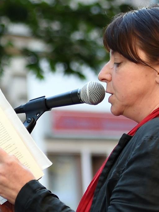 Die Schriftstellerin Annett Gröschner liest am 1. Juli 2015 in Berlin vor dem Gemüsehändler Bizim Bakkal, um gegen die Kündigung des Mietvertrags zu protestieren.