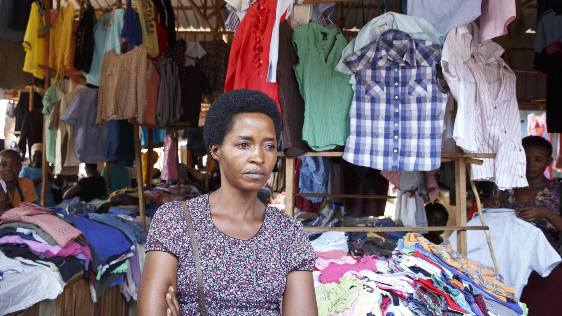Eine Strassenhaendlerin verkauft gebrauchte Kleidungsstuecke in der Markthalle von Kigali.