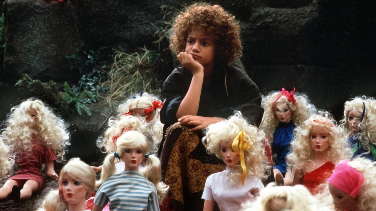 Radost Bokel als "Momo" 1985 in der Verfilmung des Kinderbuchs von Michael Ende. Ein Kind sitzt zwischen lauter Kinderpuppen und schaut nachdenklich. 
