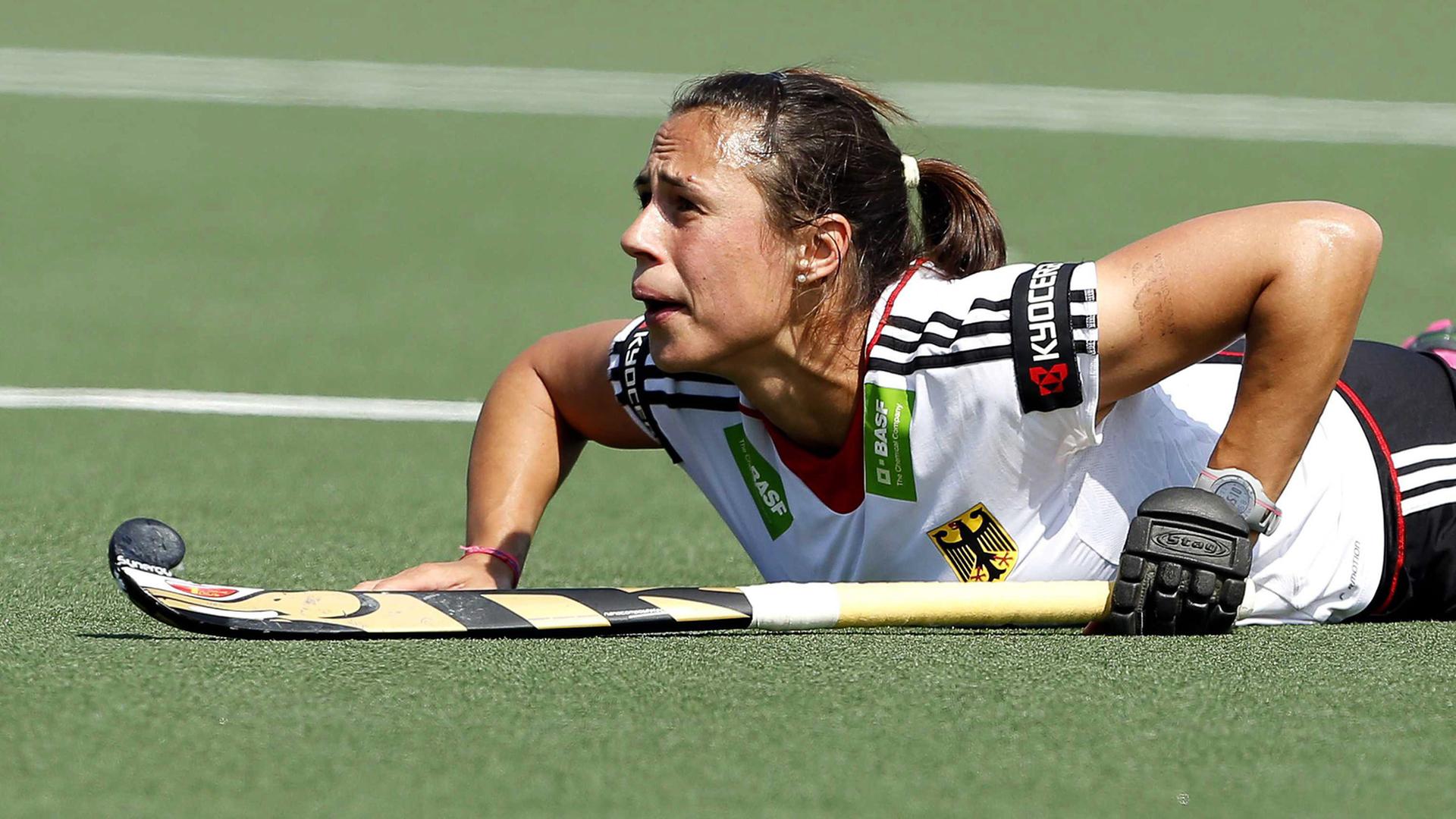 Die deutsche Hockey-Nationalspielerin Tina Bachmann liegt auf dem Feld und blickt nach vorne. Die deutsche Hockey-Nationalspielerin Tina Bachmann liegt auf dem Feld und blickt nach vorne.