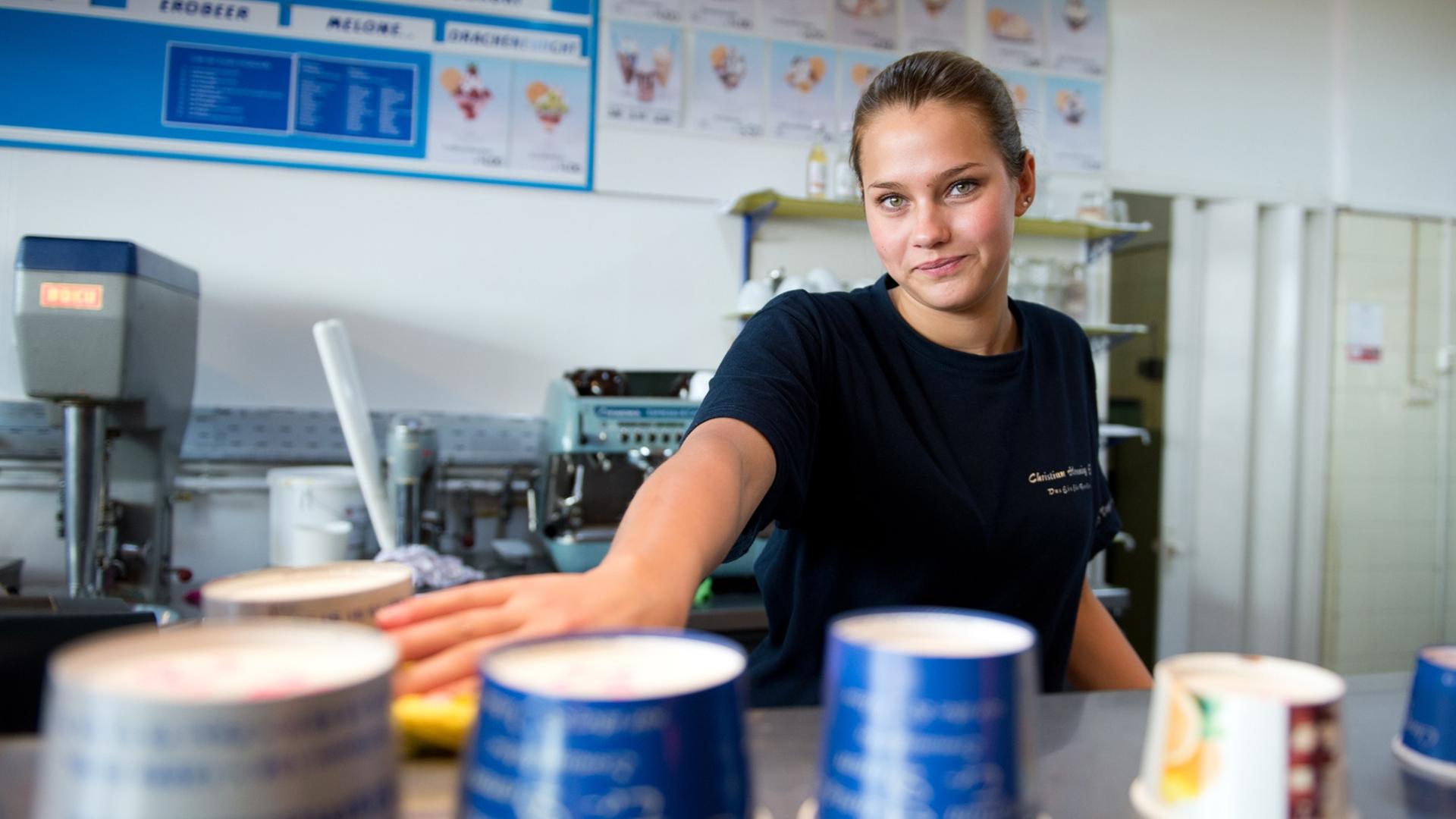 Ein Mädchen steht am 04.07.2014 in einer Eisdiele in Berlin. Die 19-jährige Schülerin arbeitet neben der Schule in einer Tempelhofer Eisdiele.