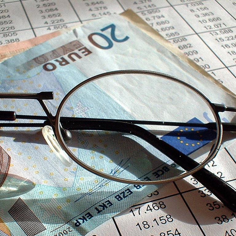 Brille, 20 Euro Schein und die Auflistung der Rückkaufswerte und Guthaben einer Lebensversicherung (Symbolbild)