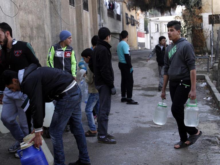 In Damaskus müssen Bewohner am 29.12.2016 Wasser an einer Zapfstelle holen, weil die Versorgung unterbrochen ist.