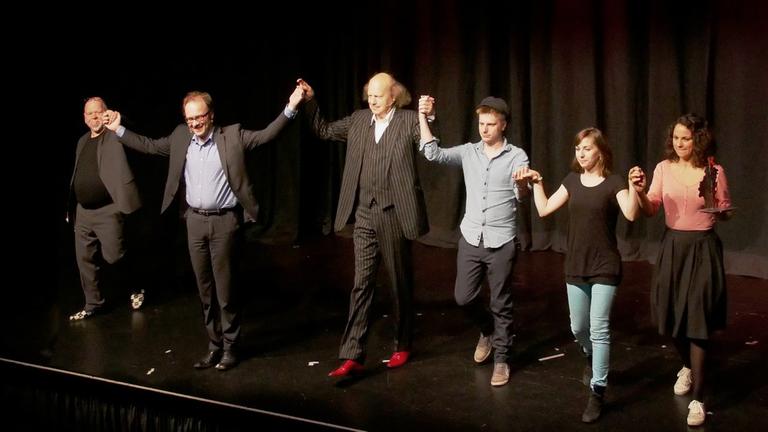Alle Preisträger des 1. Hessischen Kabarettpreises sowie der Moderator des Abends Hand in Hand zur Verbeugung auf der Bühne.