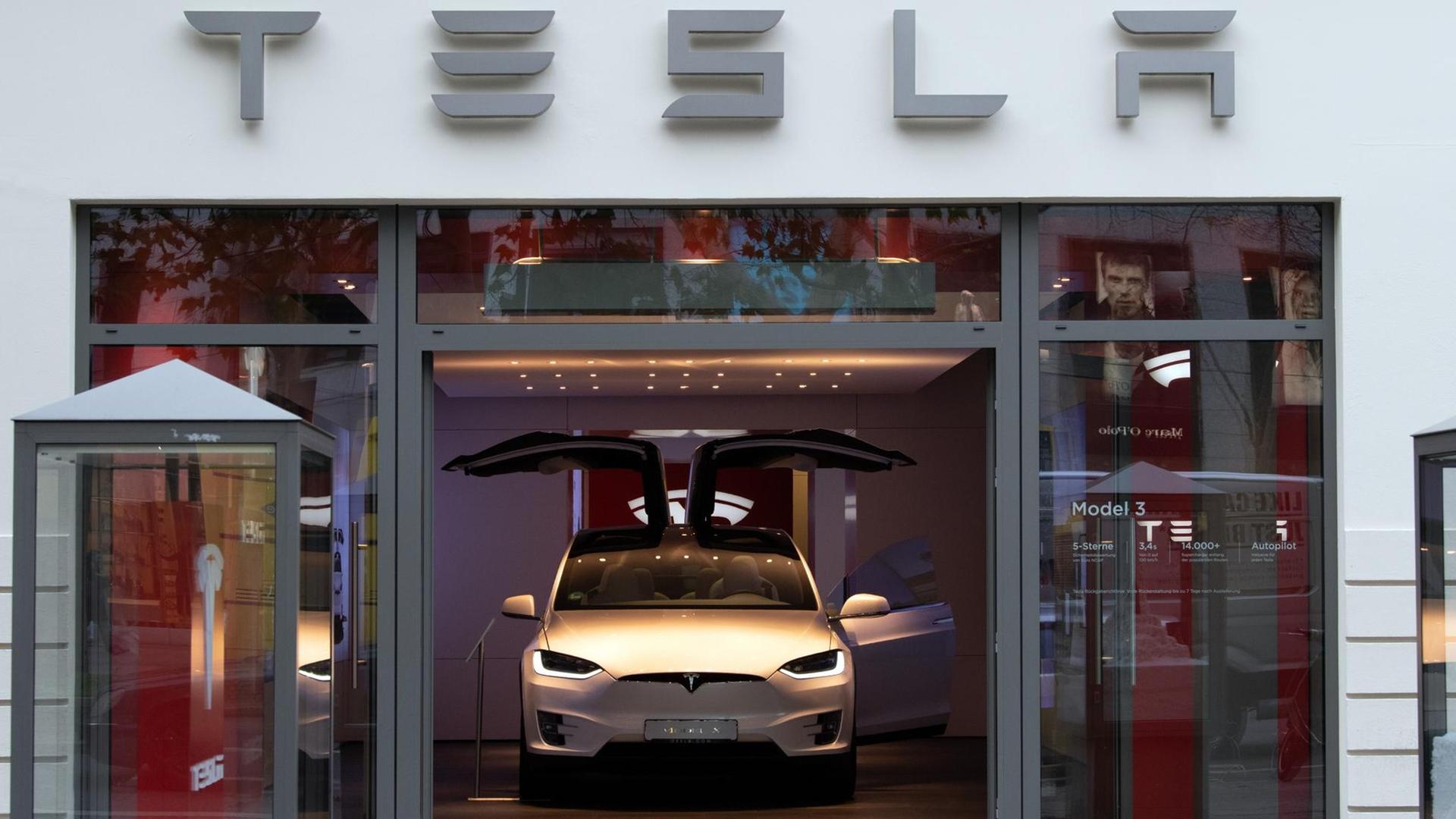 Ein Tesla "Model 3" steht mit aufgeklappten Türen im Showroom am Berliner Kudamm.