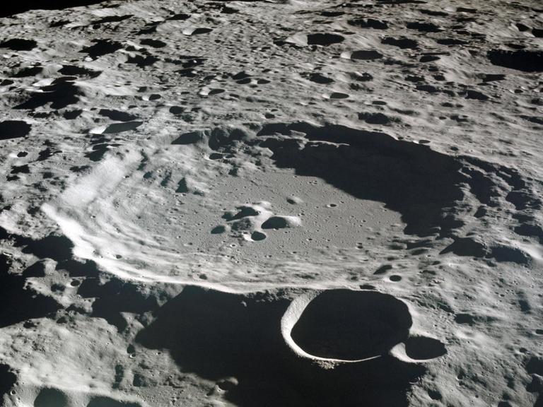 Die undatierte Apollo 11-Aufnahme zeigt die von Kratern übersäte Mondoberfläche, die allesamt durch die Einschläge von kleinen Körpern im Sonnensystem herrühren. Kein Hinweis auf Wasser: Der Mond sieht staubtrocken aus. Aber in manchen Kratern lagert Wassereis.