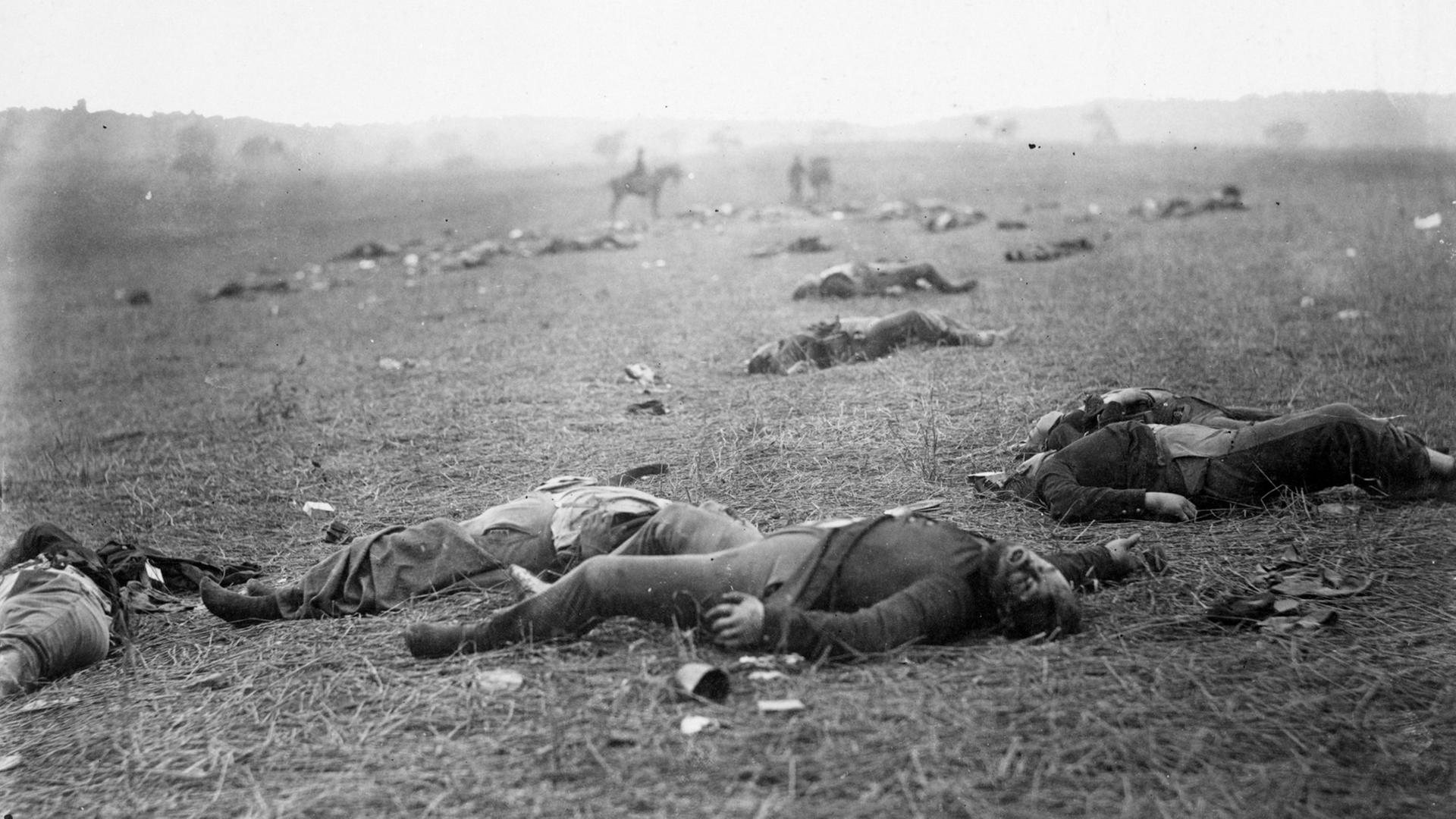 Auf dem Bild zu sehen ist das mit Verletzten und Toten übersäte Schlachtfeld von Gettysburg.