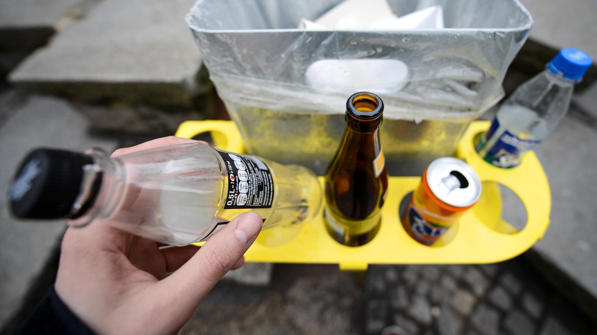 Pfandflaschen und -Dosen stehen am 10.02.2014 in einem sogenannten «Pfandring», der an einem öffentlichen Müllbehälter in Bamberg (Bayern) angebracht ist. Foto: David Ebener/dpa (zu dpa-KORR "Designer-Pfandring soll Flaschensammeln menschenwürdiger machen