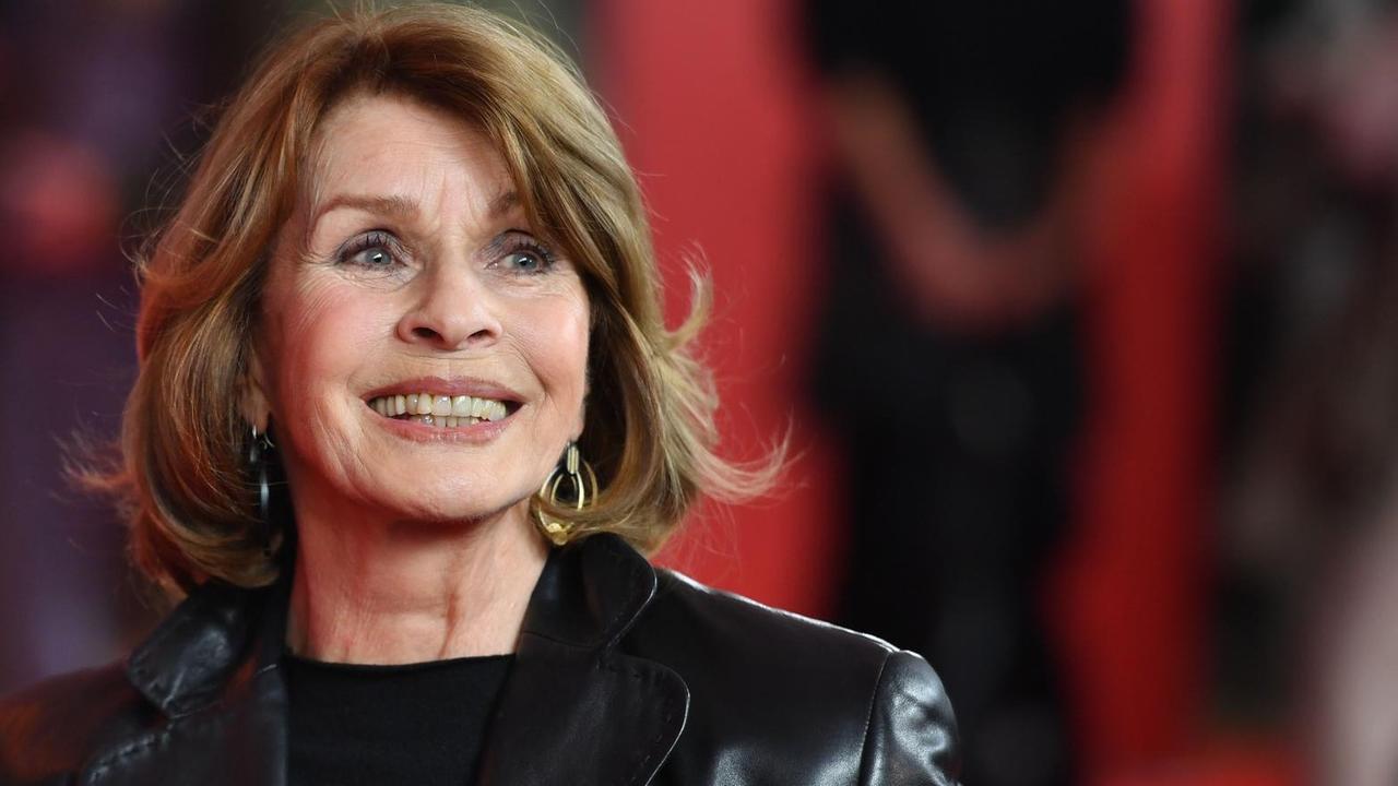 Die Schauspielerin Senta Berger lächelt bei einer Münchner Filmpremiere auf dem Roten Teppich