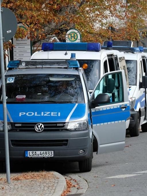 Polizisten stehen mit ihren Fahrzeugen am Bahnhof von Köthen