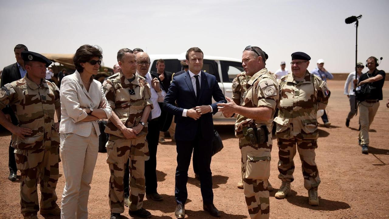 Frankreichs Präsedent Emmanuel Macron (im blauen Anzug) steht am 9. Mai 2017 mit der Verteidigungsministerin Sylvie Goulard (2. v.l.) zwischen Soldaten der französischen Anti-Terror-Operation "Barkhane" in Gao im norden von Mali.