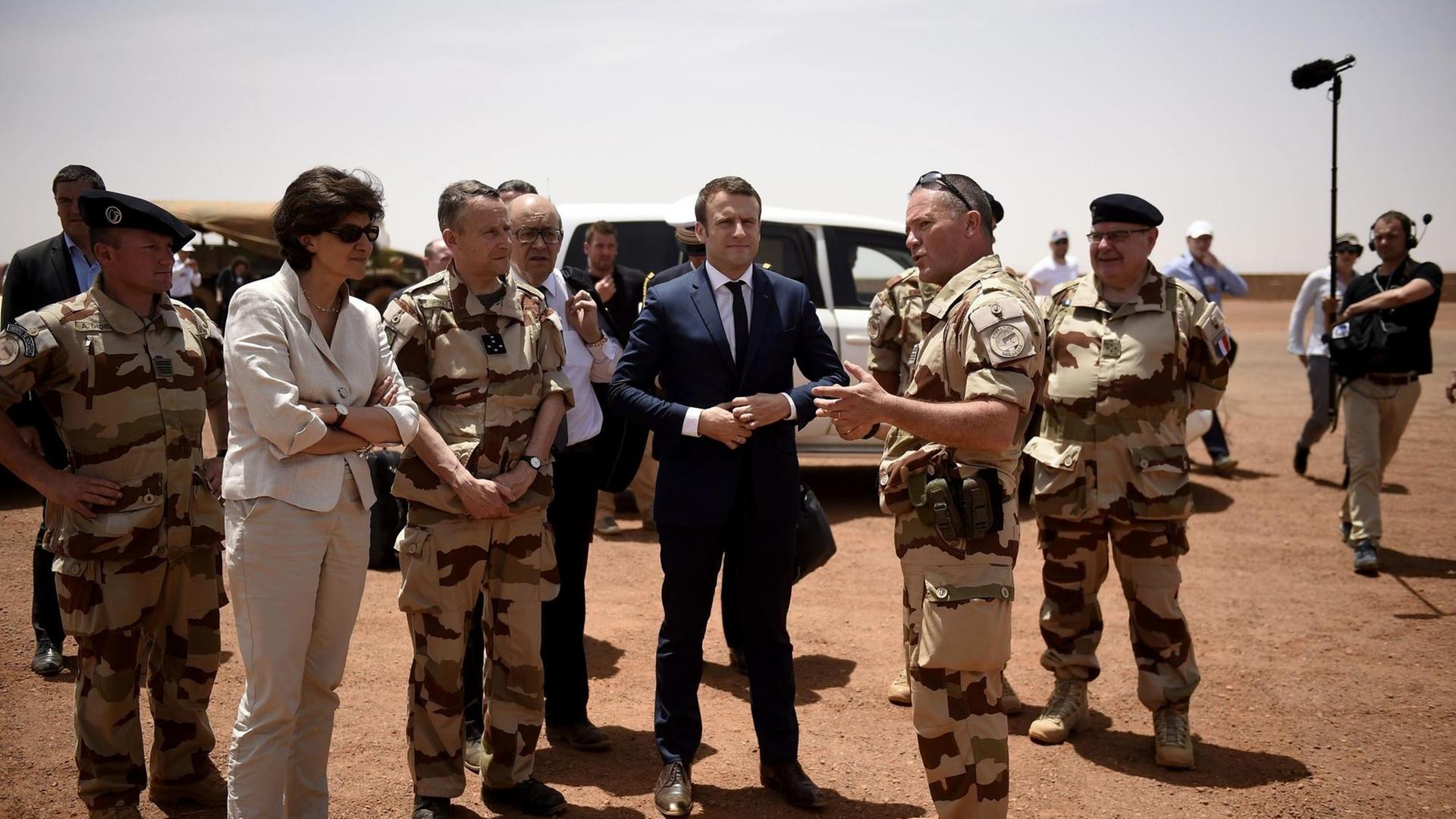 Frankreichs Präsedent Emmanuel Macron (im blauen Anzug) steht am 9. Mai 2017 mit der Verteidigungsministerin Sylvie Goulard (2. v.l.) zwischen Soldaten der französischen Anti-Terror-Operation "Barkhane" in Gao im norden von Mali.