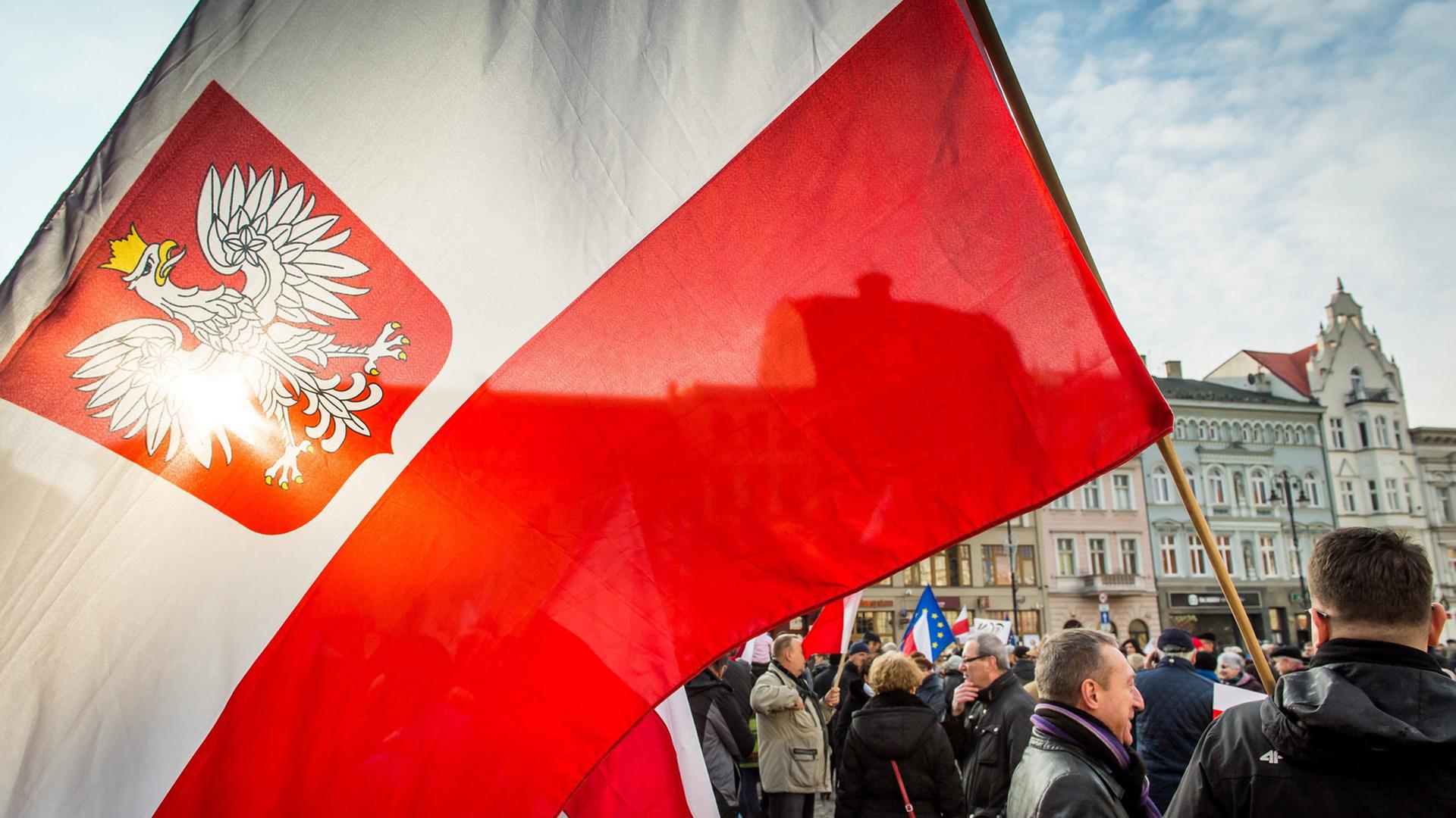 Menschen in Bydgoszcz demonstrieren mit polnischer Flagge gegen die PiS-Regierung.