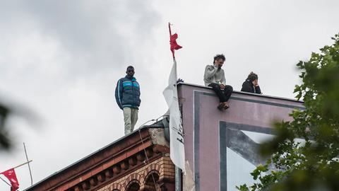 Flüchtlinge stehen auf dem Dach der besetzten ehemaligen Gerhart-Hauptmann-Schule.