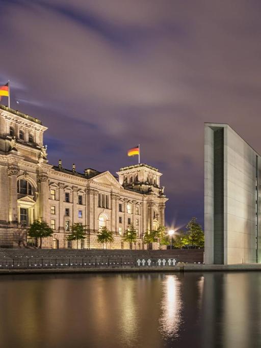 Sie sehen den Reichstag und das Paul-Löbe-Haus bei Nacht.