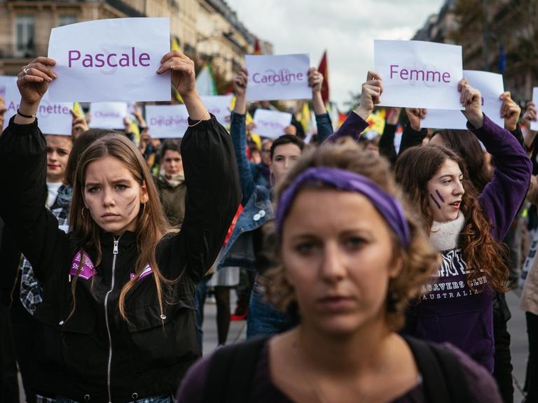 Demonstration gegen sexualisierte Gewalt und Femizide am 19. Oktober 2019 in Paris. Frauen halten Schilder hoch, auf denen die Namen von ermordeten Frauen stehen.