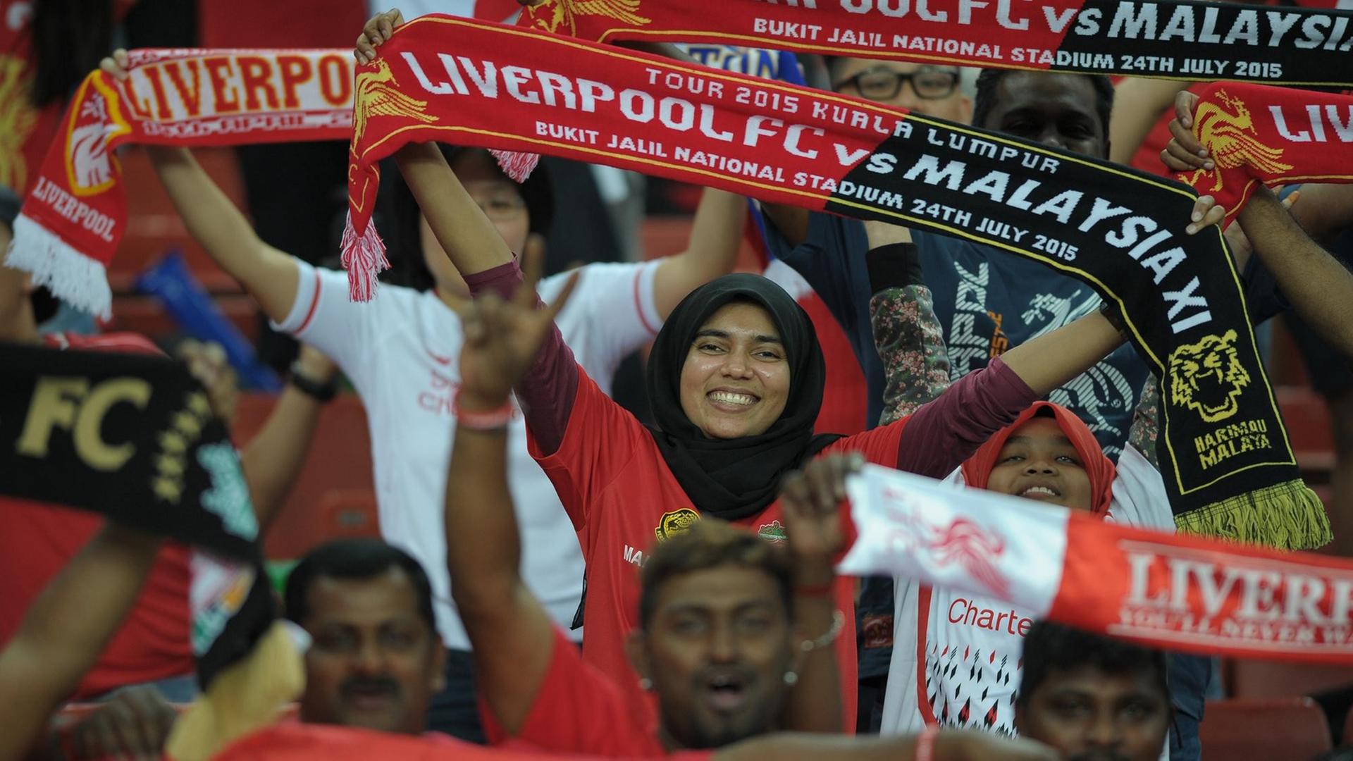 Malaysische Fans des FC Liverpool feiern ihr Team an während eines Spiels in Kuala Lumpur.