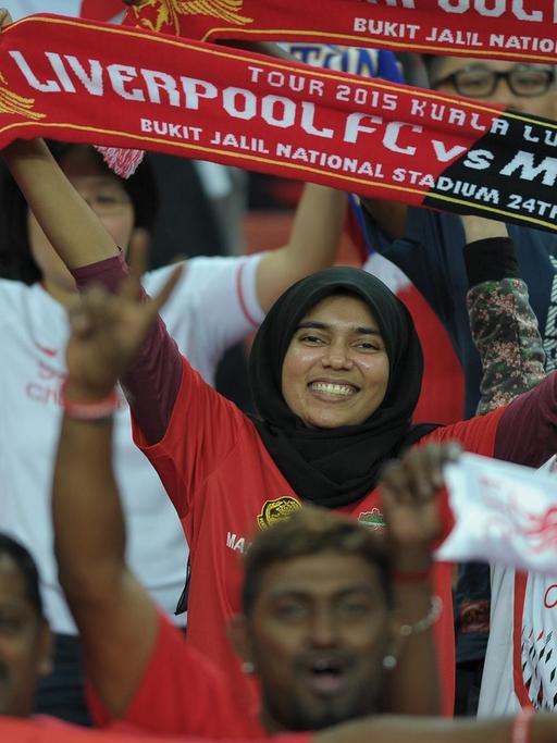 Malaysische Fans des FC Liverpool feiern ihr Team an während eines Spiels in Kuala Lumpur.