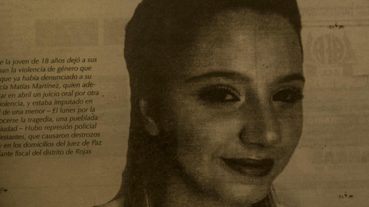 Das schwarz-weiß Porträt eines lächelnden jungen Mädchens ist in einer Zeitung abgedruckt neben einem Artikel.