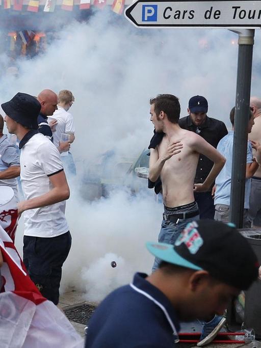 Englische Fußballfans fliehen vor Tränengas, das die französische Polizei eingesetzt hat, um Auseinandersetzungen zwischen englischen und russischen Hooligans zu beenden.