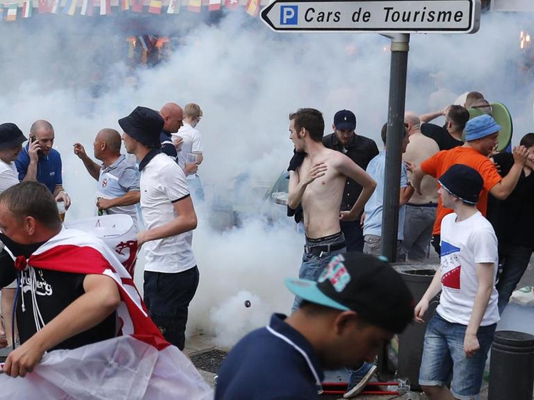 Englische Fußballfans fliehen vor Tränengas, das die französische Polizei eingesetzt hat, um Auseinandersetzungen zwischen englischen und russischen Hooligans zu beenden.