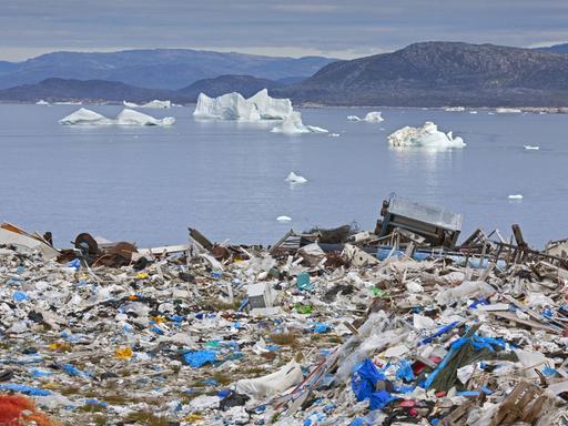 Eine Müllhalde am Ilulissat, Jakobshavn, Disko-Bay in Grönland befindet sich kurz vor dem Meer, auf dem kleine Eisberge fließen.