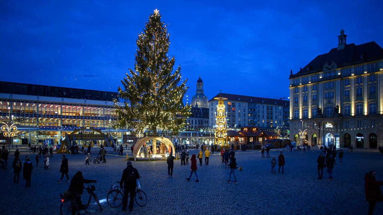 Ein überdimensionaler Schwibbogen, eine Pyramide und und ein Weihnachtsbaum stehen vor der Dresdner Kreuzkirche und sind als Teil der Dekoration für den Striezelmarkt beleuchtet.