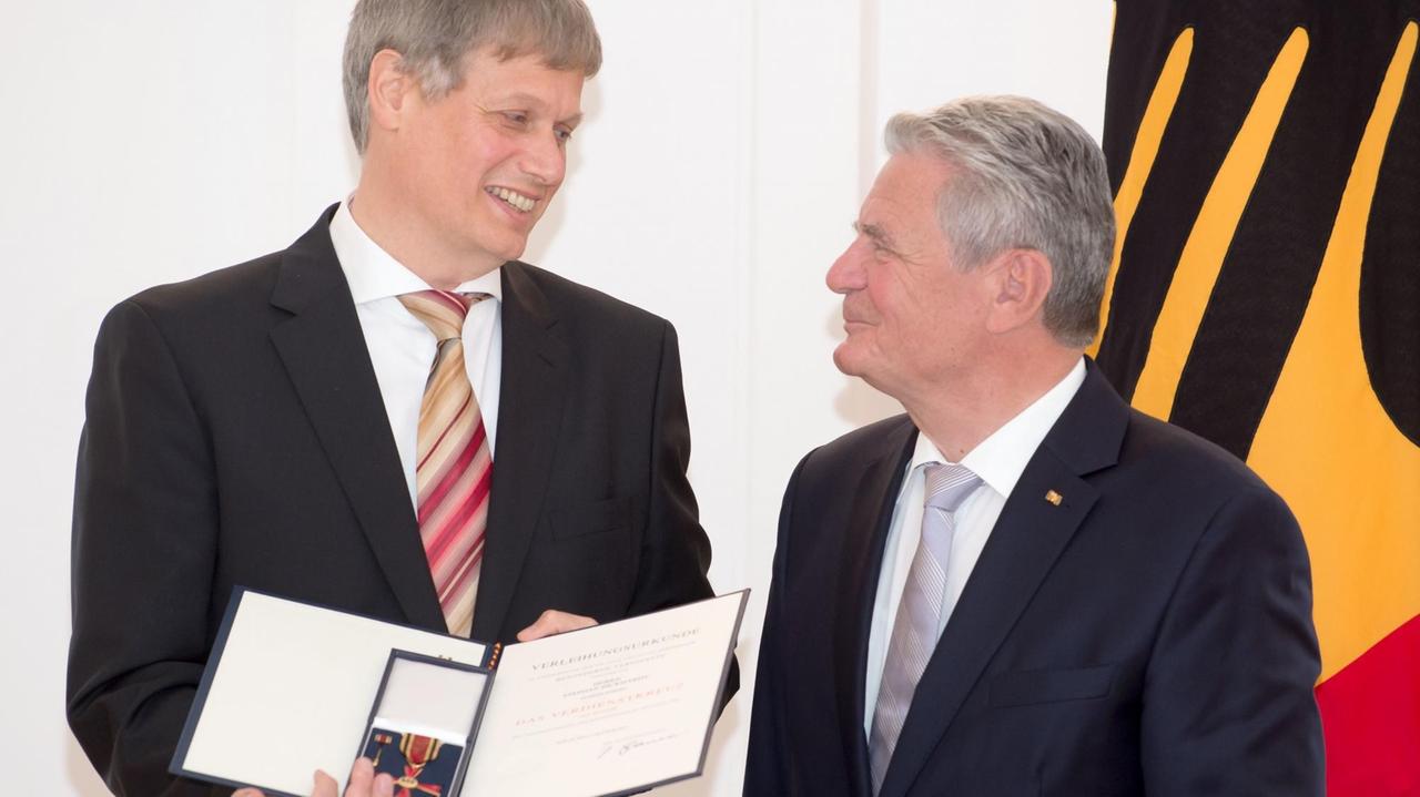 Bundespräsident Joachim Gauck überreicht Stephan Bickhardt seinen Verdienstorden.