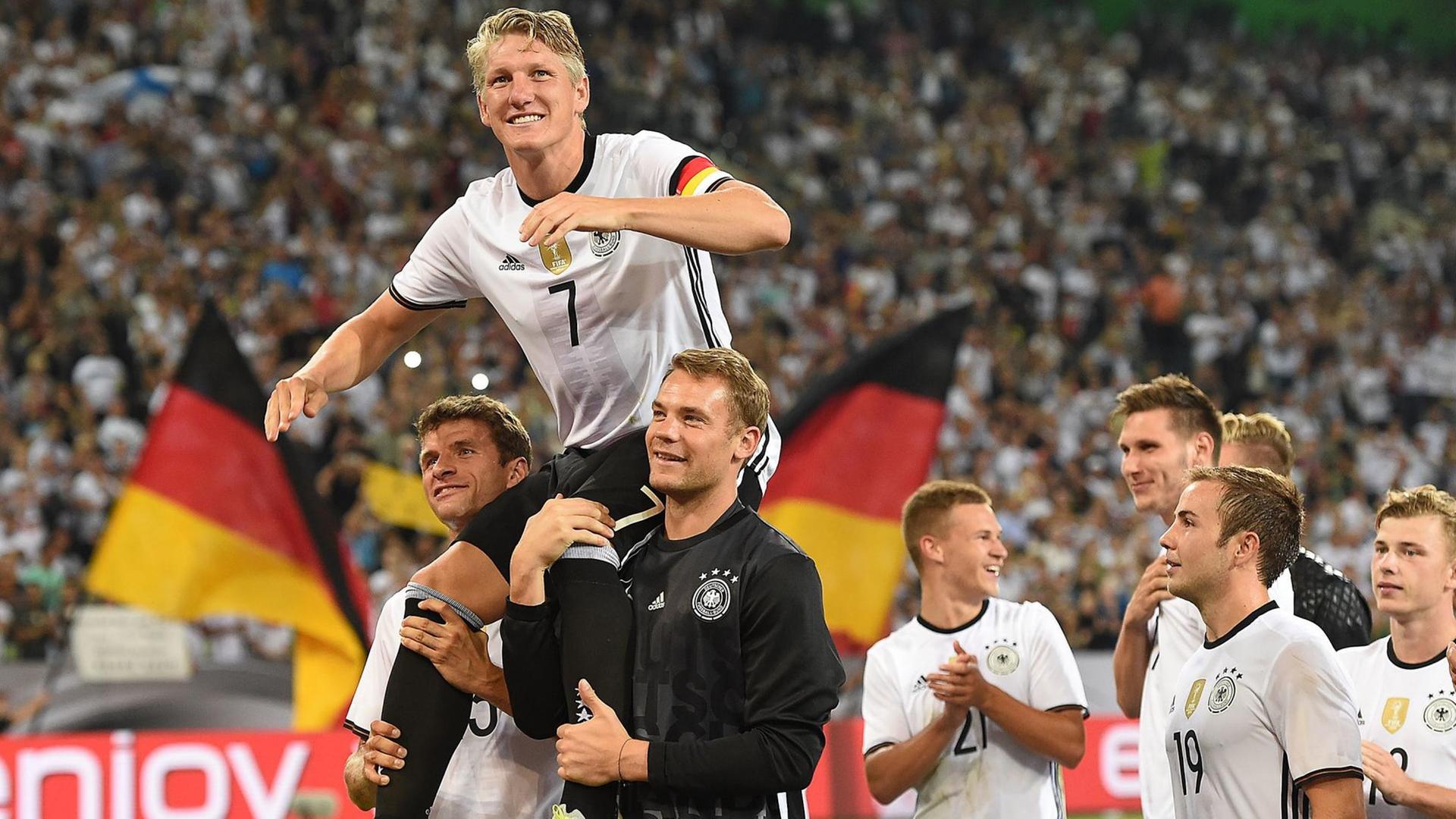 Der Kapitan der Deutschen Fußball-Nationalmannschaft, Bastian Schweinsteiger, wird von seinen Kollegen getragen.