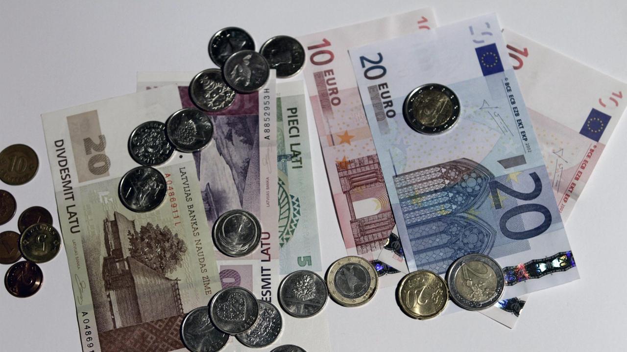 epa03732573 Lats (L) and euro banknotes and coins in Riga, Latvia, 05 June 2013. European Union member states should allow Latvia to join the eurozone on January 1, the bloc's executive said 05 June 2013, after finding that the country fulfilled all condi