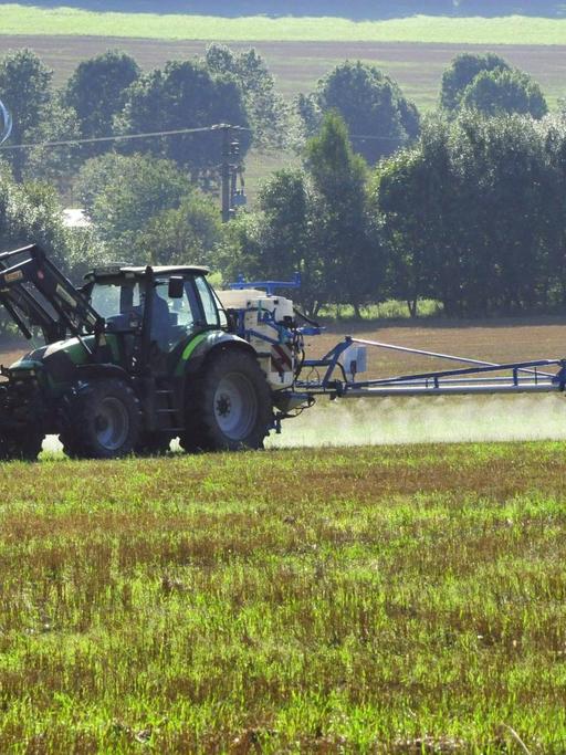  Traktor spritzt Glyphosat zur Unkrautvernichtung im Sommer auf einem Acker in Rheinland-Pfalz.