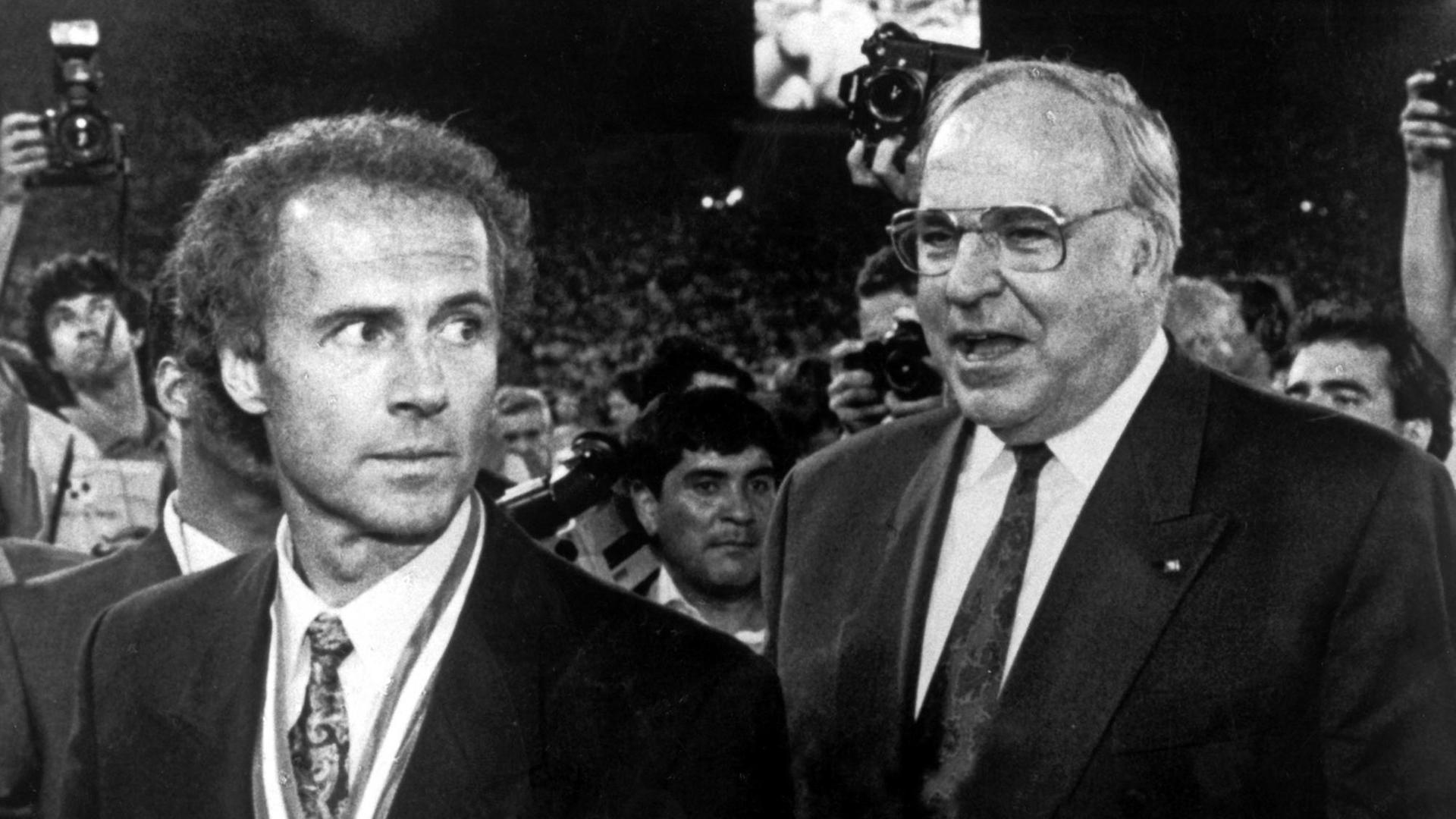 Bundeskanzler Helmut Kohl (re.) und Franz Beckenbauer bei der Siegerehrung am 08.07.1990 im Olympiastadion in Rom. Beckenbauer hatte als Teamchef die deutsche Fußballnationalmannschaft zum Weltmeistertitel geführt. Die DFB-Elf hatte das Endspiel durch ein 1:0 gegen den Titelverteidiger Argentinien gewonnen.